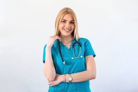 Téléchargez les photos : Medical concept of young beautiful female doctor in scrubs with phonendoscope, waist up. Woman hospital worker looking at camera and smiling, studio, white background - en image libre de droit