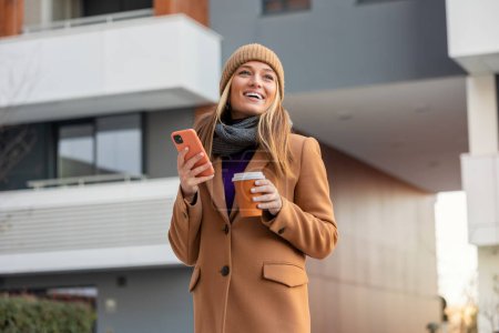 Photo for Beautiful Woman Going To Work With Coffee Walking Near Office Building. Portrait Of Successful Business Woman Holding Cup Of Hot Drink. - Royalty Free Image