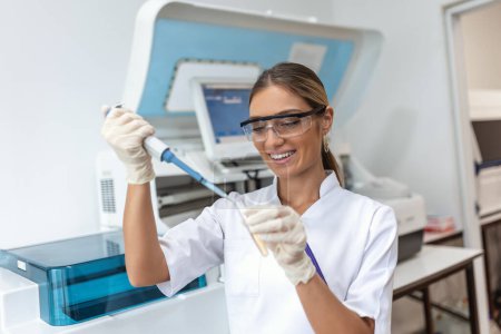 Photo for Portrait of female scientist with a pipette analyzes a liquid to extract the DNA and molecules in the test tubes in laboratory. Concept of research,biochemistry, pharmaceutical medicine - Royalty Free Image