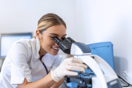 Photo for Medical Science Laboratory: Beautiful Scientist Looking Under Microscope Does Analysis of Test Sample. Young Specialists, Using Advanced Technology Equipment - Royalty Free Image