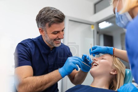 Foto de Mujer joven atractiva en la clínica de estomatología con dentista masculino. concepto de dientes sanos. - Imagen libre de derechos