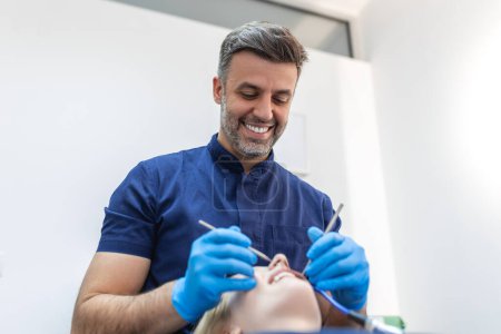 Téléchargez les photos : Jolie jeune femme dans une clinique de stomatologie avec un dentiste masculin. Concept de dents saines. - en image libre de droit