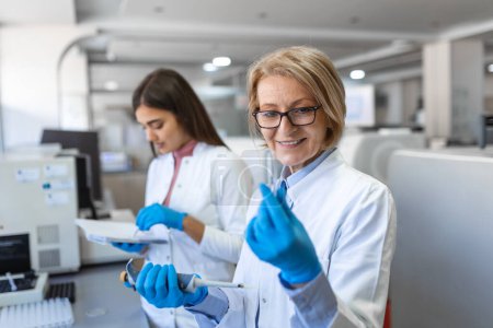 Photo for Modern Medical Research Laboratory: Female Scientist Working with Micro Pipette, Using Digital Tablet for Test Sample Analysis. Advanced Scientific Lab for Medicine, Biotechnology Development. - Royalty Free Image