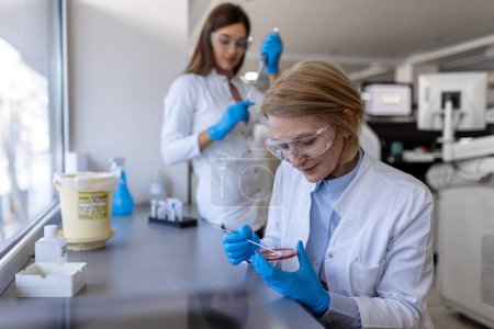 Photo for Modern Medical Research Laboratory: Two Scientists Working Together Analysing Chemicals in Laboratory, Discussing Problem. Advanced Scientific Lab for Medicine, Biotechnology, Molecular Biology - Royalty Free Image