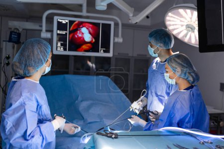 Der Chirurg hält das Instrument in den Bauch des Patienten. Der Chirurg führt laparoskopische Operationen im Operationssaal durch. Minimalinvasive Chirurgie.