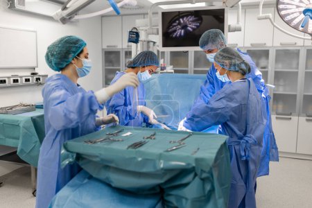 Photo for Surgical team performing surgery in modern operation theater,Team of doctors concentrating on a patient during a surgery,Team of doctors working together during a surgery in operating room, - Royalty Free Image