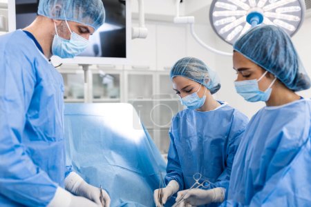 Foto de Doctor and assistant nurse operating for help patient from dangerous emergency case .Surgical instruments on the sterile table in the emergency operation room in the hospital.Health care and Medical - Imagen libre de derechos