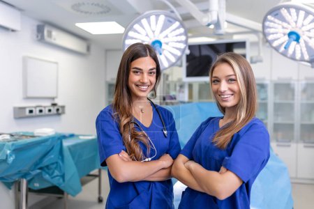 Photo for Young female medical professionals standing together. concept of health protection. Successful team of medical doctors are looking at camera and smiling while standing in hospital - Royalty Free Image