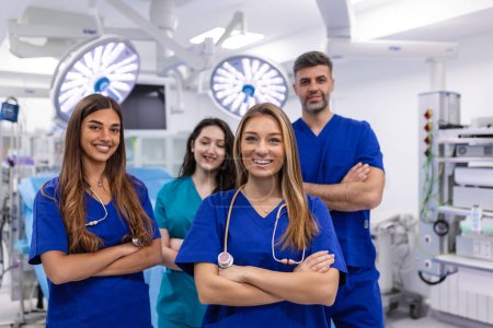 Photo for Closeup front view of group of mixed age doctors and nurses standing side by side and looking at the camera. Young female doctor is in the front. - Royalty Free Image