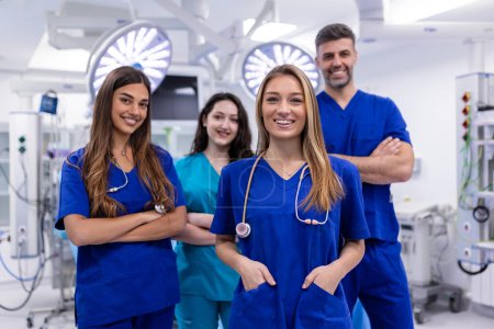 Closeup front view of group of mixed age doctors and nurses standing side by side and looking at the camera. Young female doctor is in the front.
