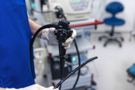 Téléchargez les photos : Docteur proctologue tenant l'endoscope pendant la coloscopie. Sonde colonoscope. Médecin gastroentérologue avec sonde pour effectuer la gastroscopie et la coloscopie - en image libre de droit