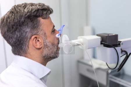 Téléchargez les photos : Homme testant la fonction respiratoire par spirométrie. Diagnostic de la fonction respiratoire dans les maladies pulmonaires - en image libre de droit