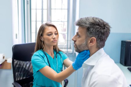 Photo for Endocrinologist examining throat of man in clinic. Men with thyroid gland test . Endocrinology, hormones and treatment. Inflammation of the sore throat - Royalty Free Image