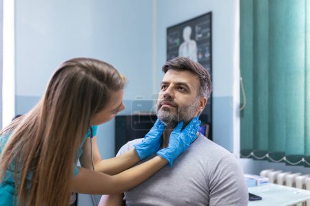 Photo for Medicine, healthcare and medical exam concept - doctor or nurse checking patient's tonsils at hospital. Endocrinologist examining throat of young man in clinic - Royalty Free Image
