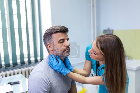 Photo for Medicine, healthcare and medical exam concept - doctor or nurse checking patient's tonsils at hospital. Endocrinologist examining throat of young man in clinic - Royalty Free Image