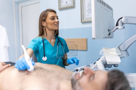 Téléchargez les photos : Le docteur fait une échographie thoracique sur l'homme dans la chambre d'hôpital. Examen du concept du cœur et des vaisseaux - en image libre de droit