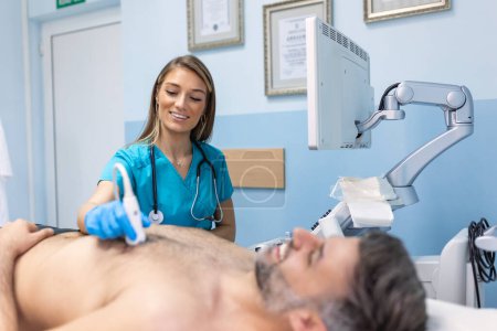 Téléchargez les photos : Médecin féminin utilisant un équipement ultrasonore moderne et examinant le cœur du patient masculin allongé sur la table médicale pendant le diagnostic à l'hôpital - en image libre de droit