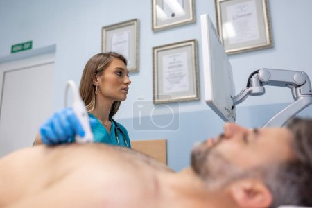 Téléchargez les photos : Le docteur fait une échographie thoracique sur l'homme dans la chambre d'hôpital. Examen du concept du cœur et des vaisseaux - en image libre de droit