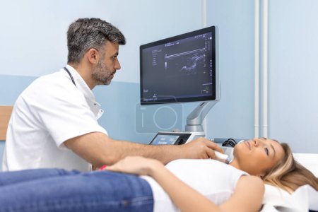 Photo for Woman patient receives thyroid diagnostics. Treatment of thyrotoxicosis, and hypothyroidism. Ultrasound diagnostics of the endocrine system and thyroid - Royalty Free Image