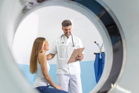 Téléchargez les photos : Médecin homme donnant des informations à la femme avant l'examen IRM. Technologie d'imagerie par résonance magnétique dans une clinique médicale spécialisée. - en image libre de droit