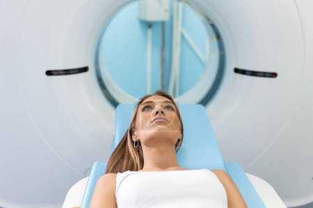 Foto de Mujer sometida a tomografía computarizada mientras el doctor usa computadoras. Paciente acostado en la cama del escáner TC esperando ser escaneado. - Imagen libre de derechos