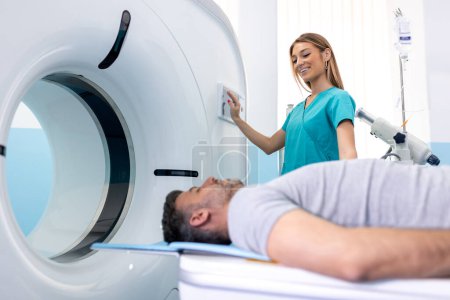 Foto de Doctora mirando a la paciente sometida a tomografía computarizada. Médico en uniforme usando máquina de tomografía con paciente acostado en el hospital - Imagen libre de derechos