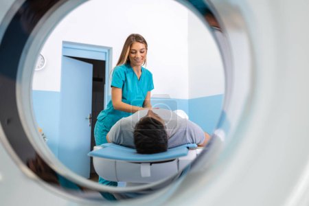 Foto de Doctora mirando a la paciente sometida a tomografía computarizada. Médico en uniforme usando máquina de tomografía con paciente acostado en el hospital - Imagen libre de derechos