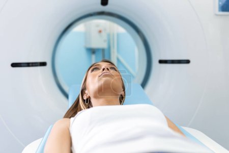 Foto de Mujer sometida a tomografía computarizada mientras el doctor usa computadoras. Paciente acostado en la cama del escáner TC esperando ser escaneado. - Imagen libre de derechos