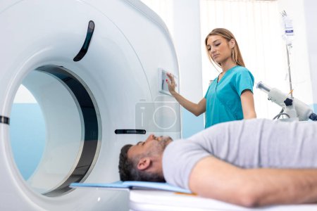 Female Doctor Looking At Patient Undergoing CT Scan. Doctor in uniform using tomography machine with lying patient in hospital