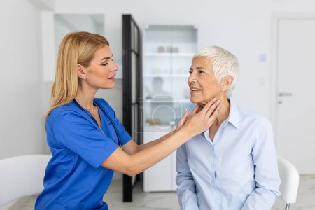Photo for Endocrinologist examining throat of senior woman in clinic. Women with thyroid gland test . Endocrinology, hormones and treatment. Inflammation of the sore throat - Royalty Free Image