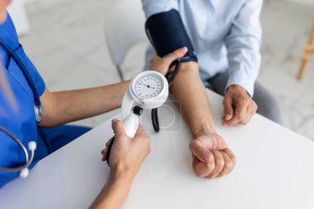 Téléchargez les photos : Médecin utilisant un sphygmomanomètre avec stéthoscope pour vérifier la pression artérielle d'un patient à l'hôpital
. - en image libre de droit