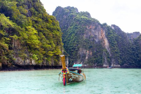 Foto de Phi Phi, Tailandia - 23 de noviembre de 2023: Barco de madera cerca de las islas Phi Phi - uno de los lugares más famosos con vistas al paraíso y rocas verdes - Imagen libre de derechos