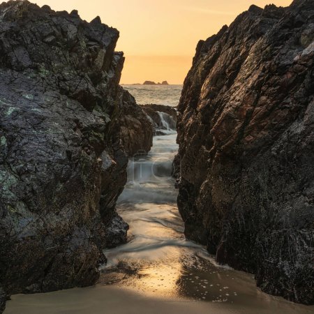 Téléchargez les photos : Superbe lever de soleil sur le paysage de Kynance Cove à Corwnall en Angleterre avec un ciel vibrant et un magnifique océan turquoise - en image libre de droit