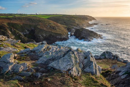 Photo for Beautiful sunset landscape image of Cornwall cliff coastline with tin mines in background viewed from Pendeen Lighthouse headland - Royalty Free Image