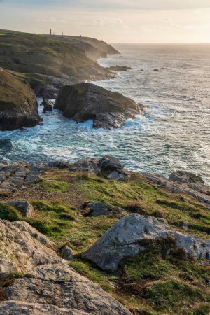 Photo for Beautiful sunset landscape image of Cornwall cliff coastline with tin mines in background viewed from Pendeen Lighthouse headland - Royalty Free Image