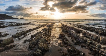 Téléchargez les photos : Superbe image de paysage de coucher de soleil de Welcome Mouth Beach dans le Devon en Angleterre avec de belles formations rocheuses - en image libre de droit