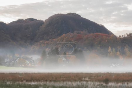 Téléchargez les photos : Superbe image du lever du soleil du paysage d'automne regardant vers la vallée de Borrowdale depuis Derwentwater dans le Lake District avec du brouillard roulant à travers le paysage - en image libre de droit