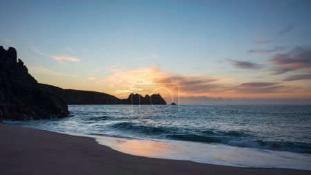Photo for Beautiful sunrise landscape at Porthcurno beach in Cornwall England with stunning colours and mood - Royalty Free Image