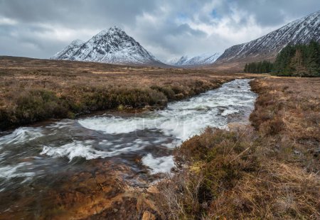 Photo for Beautiful Winter landscape image of River Etive in foreground with iconic snowcapped Stob Dearg Buachaille Etive Mor mountain in the background - Royalty Free Image