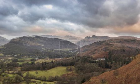 Foto de Beautiful Winter sunrise landscape view from Loughrigg Fell across the countryside towards Langdale Pikes and Pike O'Blisco in the Lake District - Imagen libre de derechos