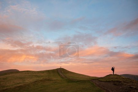 Photo for Beautiful Winter sunset landscape over Latrigg Fell in Lake District with two people on hilltop admiring sunset - Royalty Free Image