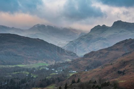 Téléchargez les photos : Beautiful Winter sunrise landscape view from Loughrigg Fell across the countryside towards Langdale Pikes and Pike O'Blisco in the Lake District - en image libre de droit