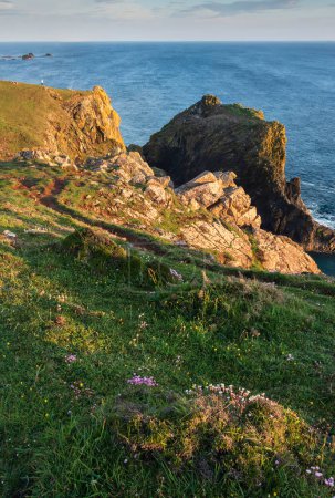 Foto de Impresionante amanecer y puesta de sol paisaje imagen de l turista popular; ubicación en Kynance Cove en Cornwall Inglaterra con cielo colorido - Imagen libre de derechos