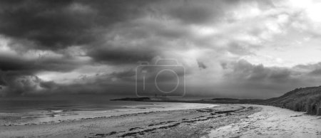 Photo for Beautiful unusual  black and white moody Winter landscape of snow on Embleton Bay beach in Northumberland England - Royalty Free Image