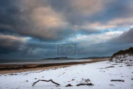 Photo for Beautiful unusual moody Winter landscape of snow on Embleton Bay beach in Northumberland England - Royalty Free Image