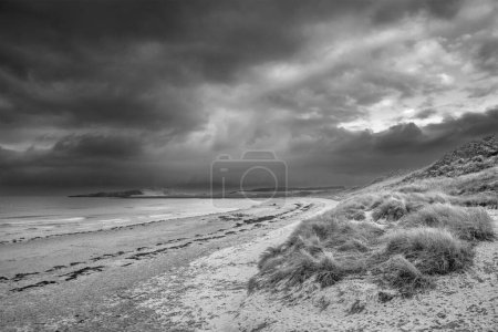 Photo for Beautiful unusual moody Winter  black and white landscape of snow on Embleton Bay beach in Northumberland England - Royalty Free Image
