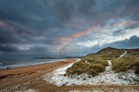 Téléchargez les photos : Beau paysage d'hiver insolite et lunatique de neige sur la plage d'Embleton Bay dans le Northumberland en Angleterre - en image libre de droit