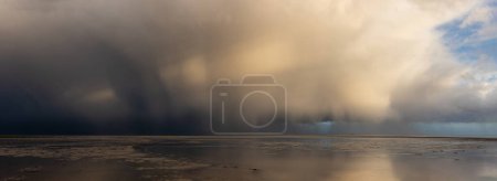 Foto de Impresionantes cielos tormentosos dramáticos sobre el paisaje panorámico del océano con lluvias fuertes distantes - Imagen libre de derechos