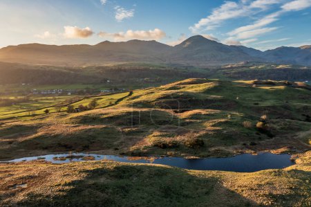 Beautiful Spring sunset landscape aerial drone image in Lake District looking towards Old Man of Coniston
