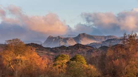 Stunning Spring landscape image in Lake District looking towards Langdale Pikes during colorful sunset